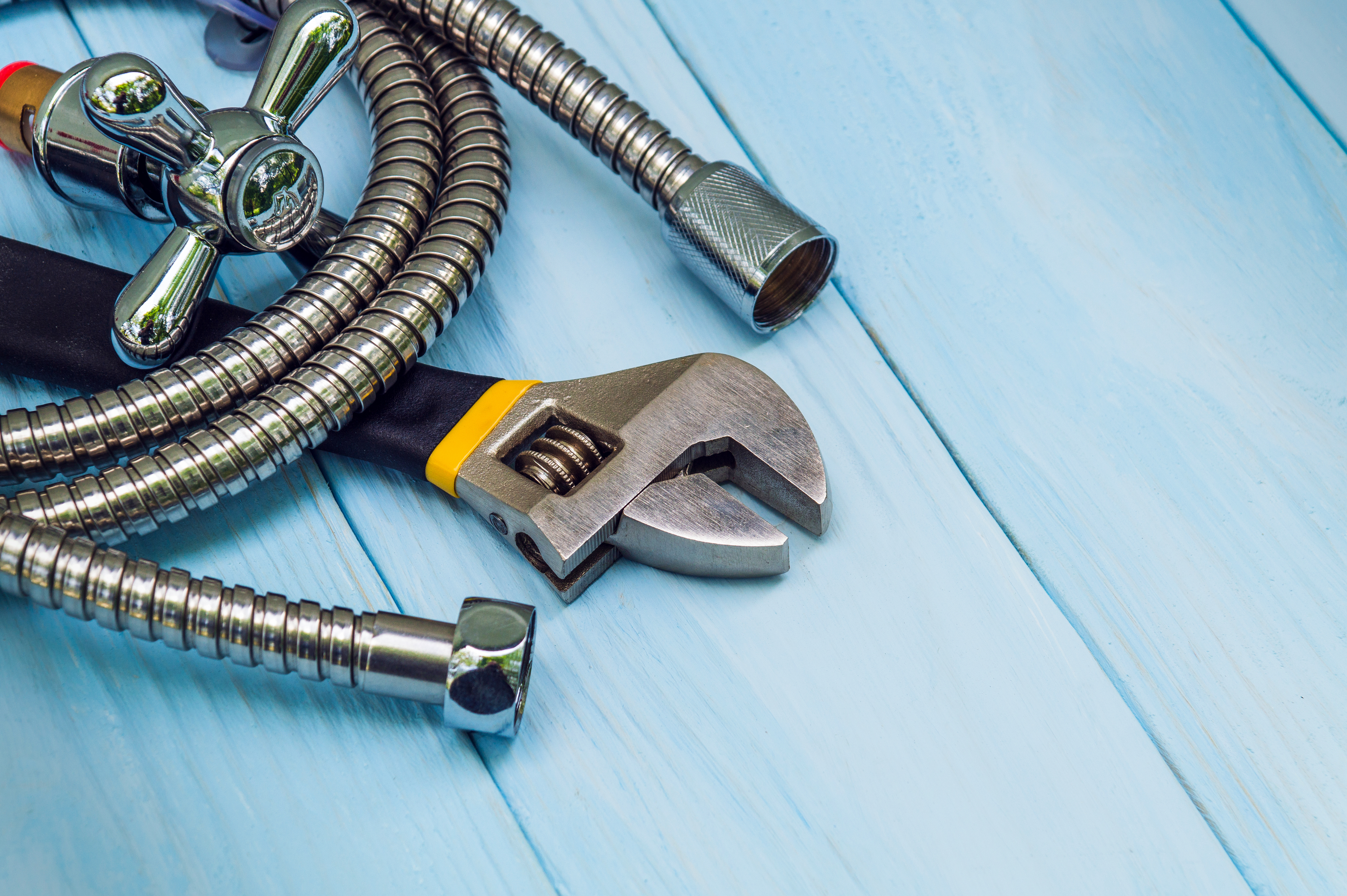 Plumbing tools and gloves laid out for connecting water hoses